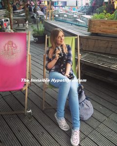 Rachel sat smiling in a deckchair at a bar