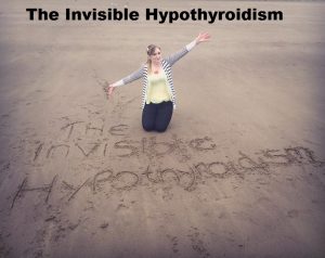 Rachel kneeling on a beach with a handwritten sign saying 'The Invisible Hypothyroidism'