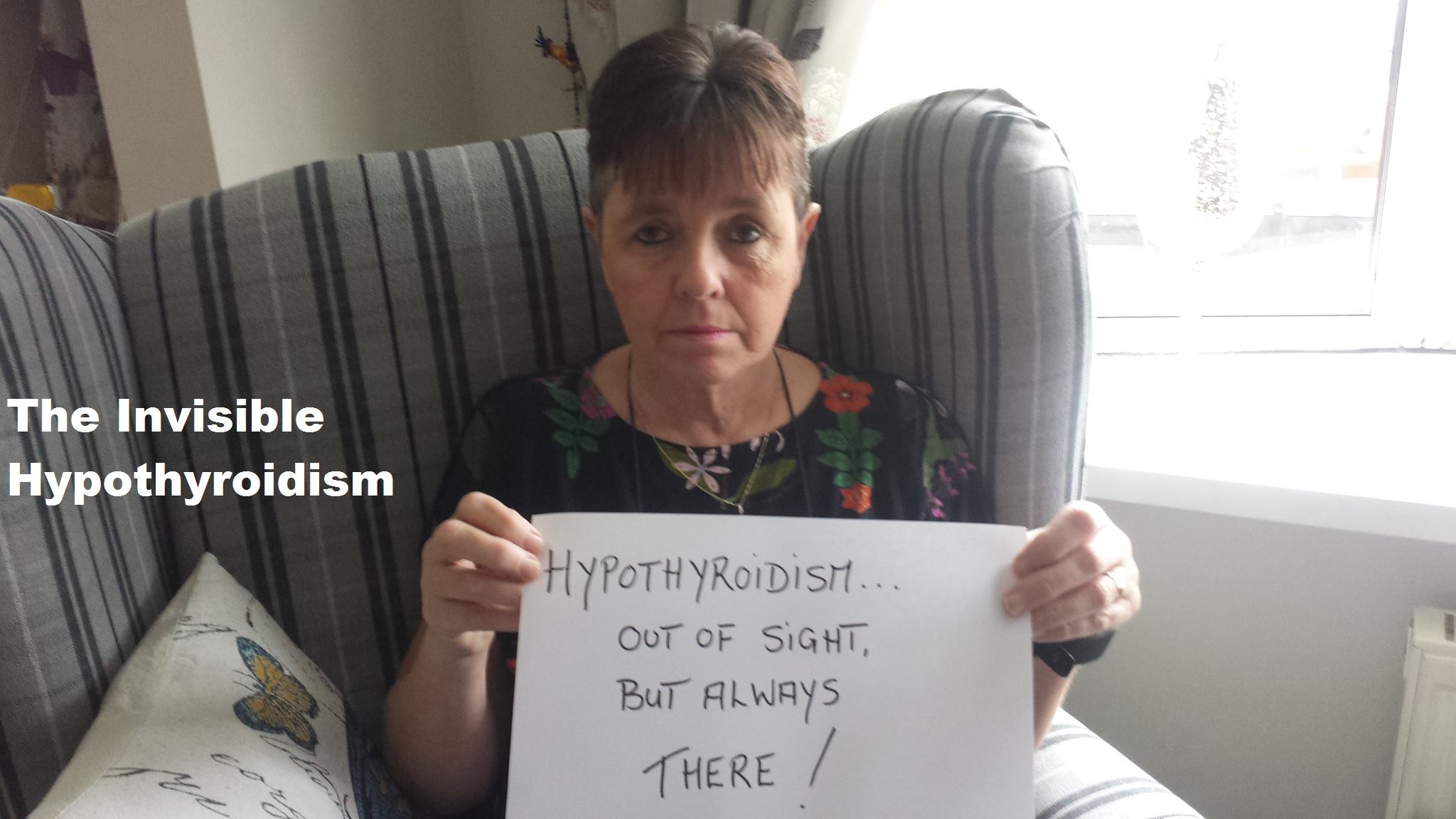 A Thyroid Patient holding a sign saying 'Hypothyroidism... Out of sight, but always there!'