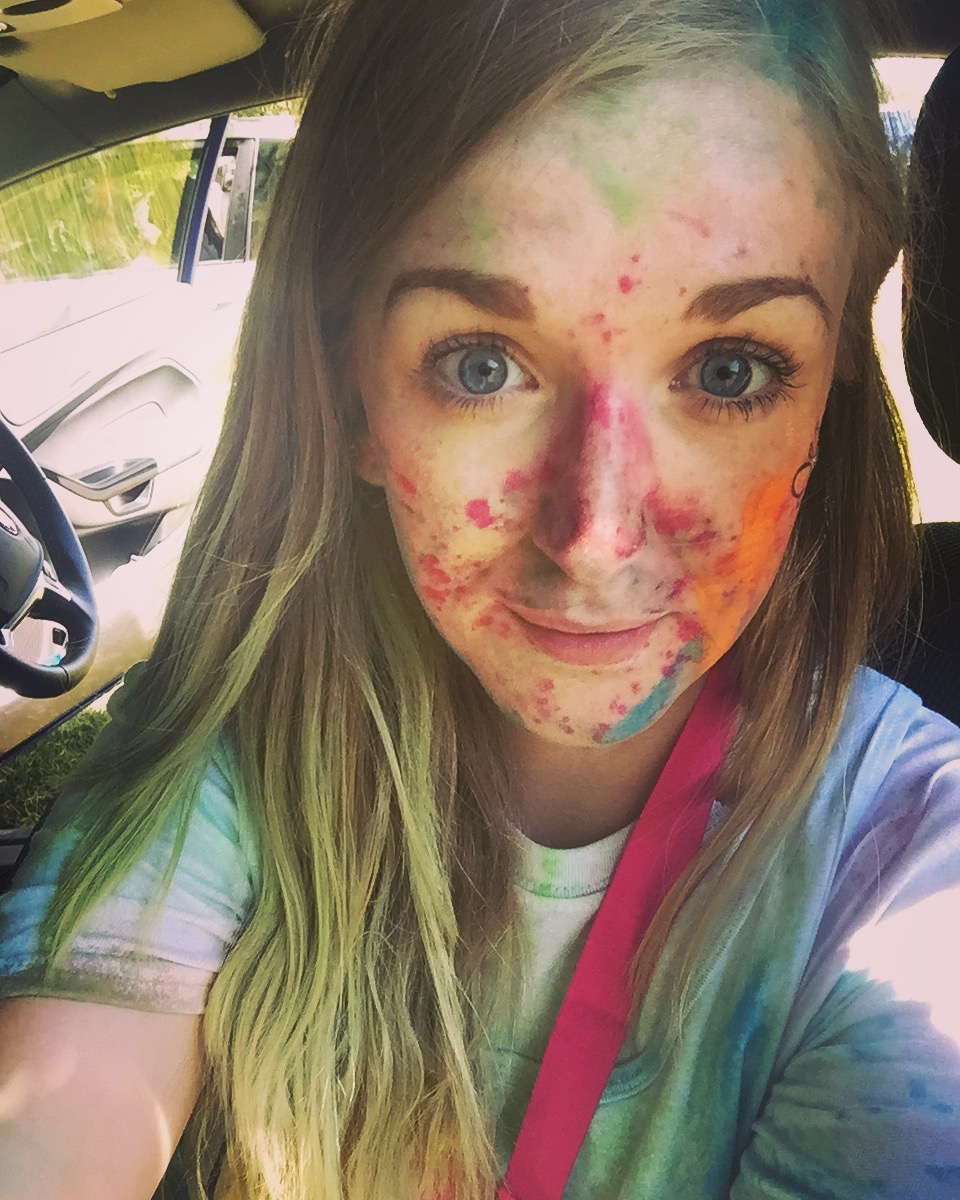 A selfie of Rachel covered in multicoloured powder