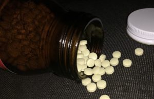 A photo of NDT medication coming out of a medicine bottle.